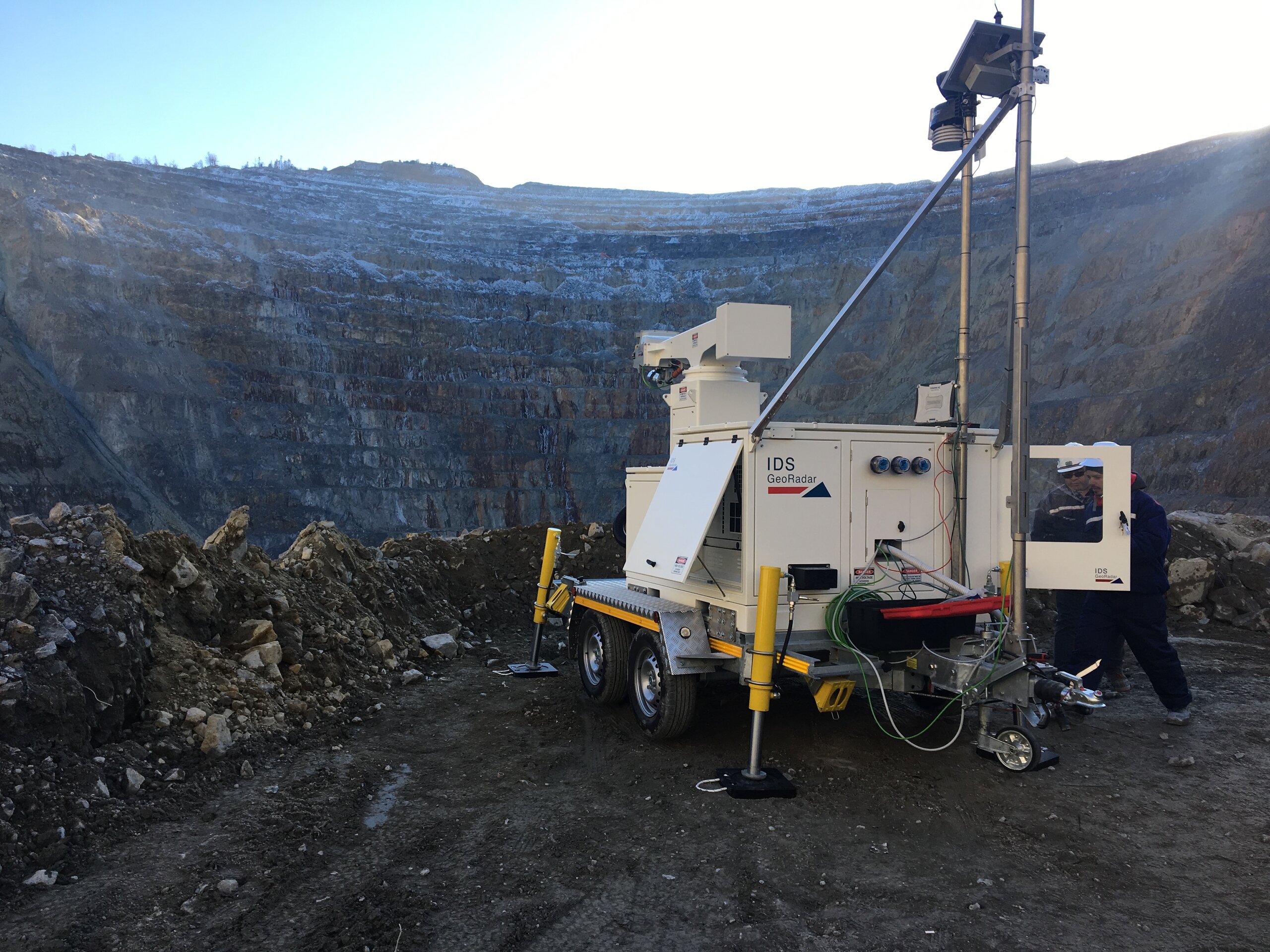 A slope monitoring device perched on the edge of a mining pit